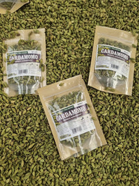 Semillas de cardamomo entero sobre fondo de especias verdes